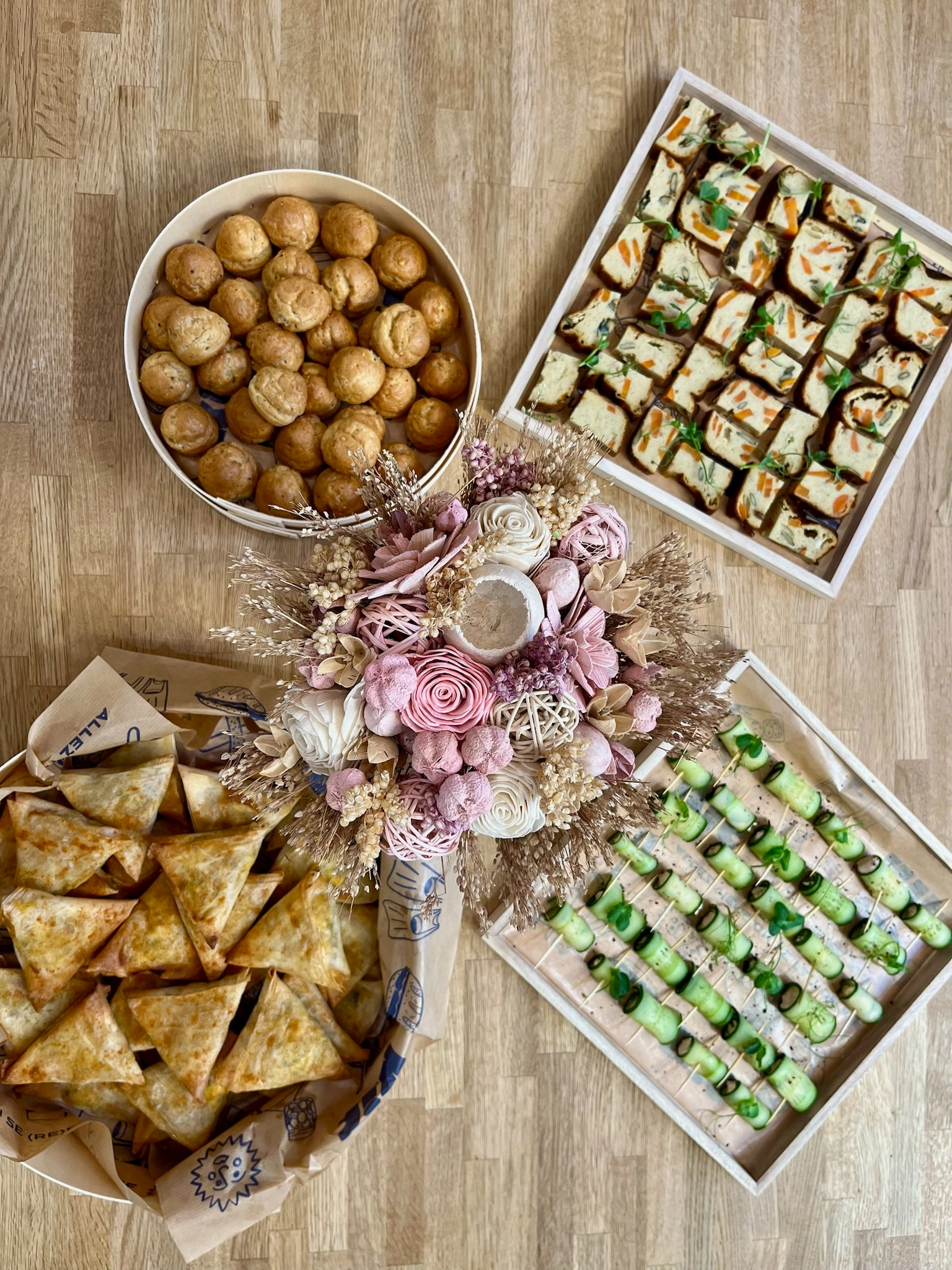 Buffet pour une prestation traiteur entreprise Pièces cocktail : gougères au parmesan, involtini concombre fourré à la crème de truite fumée, cake carotte, cumin et graines de courges, samossas au potimarron