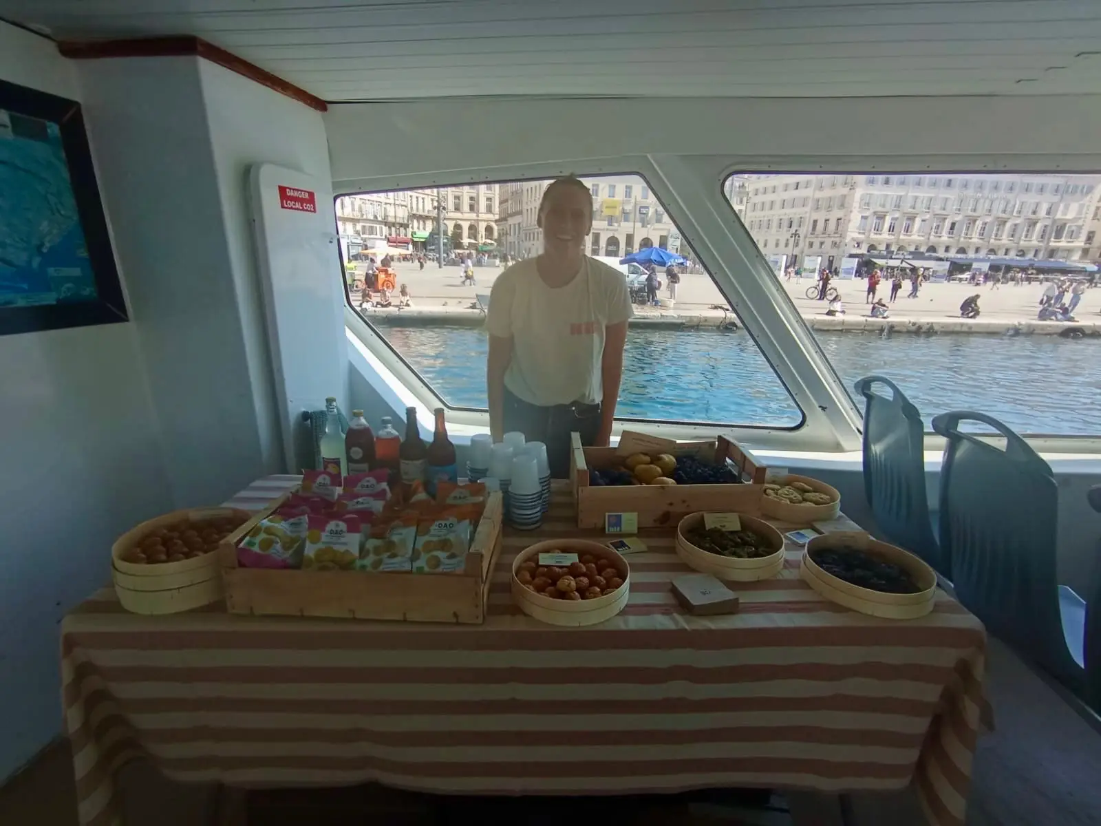 Serveuse sur un buffet en bateau, avec des gougères, cookies et snacks