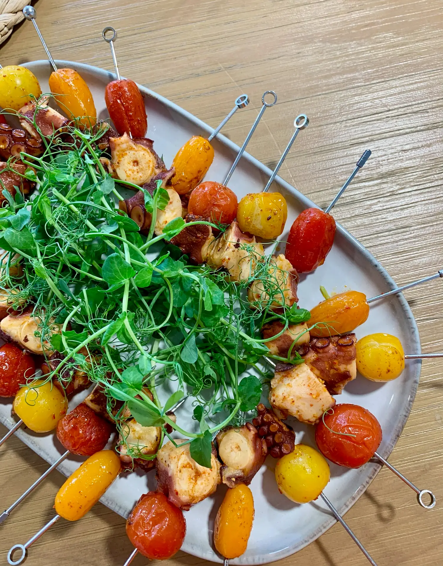 Brochettes de poulpe mariné avec tomates cerises et micro pousses sur une prestation traiteur en entreprise